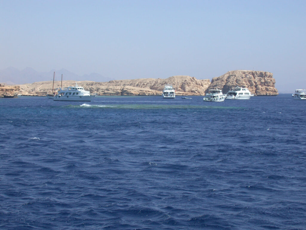 Barcos de mergulho ancorados diante das falésias claras de Ras Mohammed, acima de Shark e Yolanda Reef