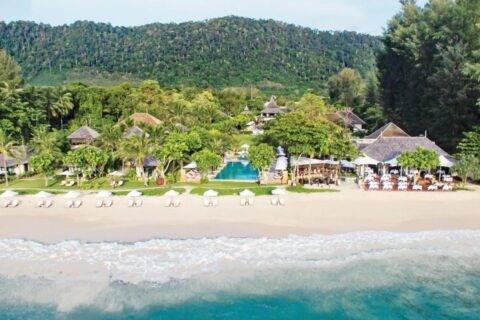 O Layana Resort visto do mar, com praia, guarda-sóis brancos, piscina e telhados sob as palmeiras