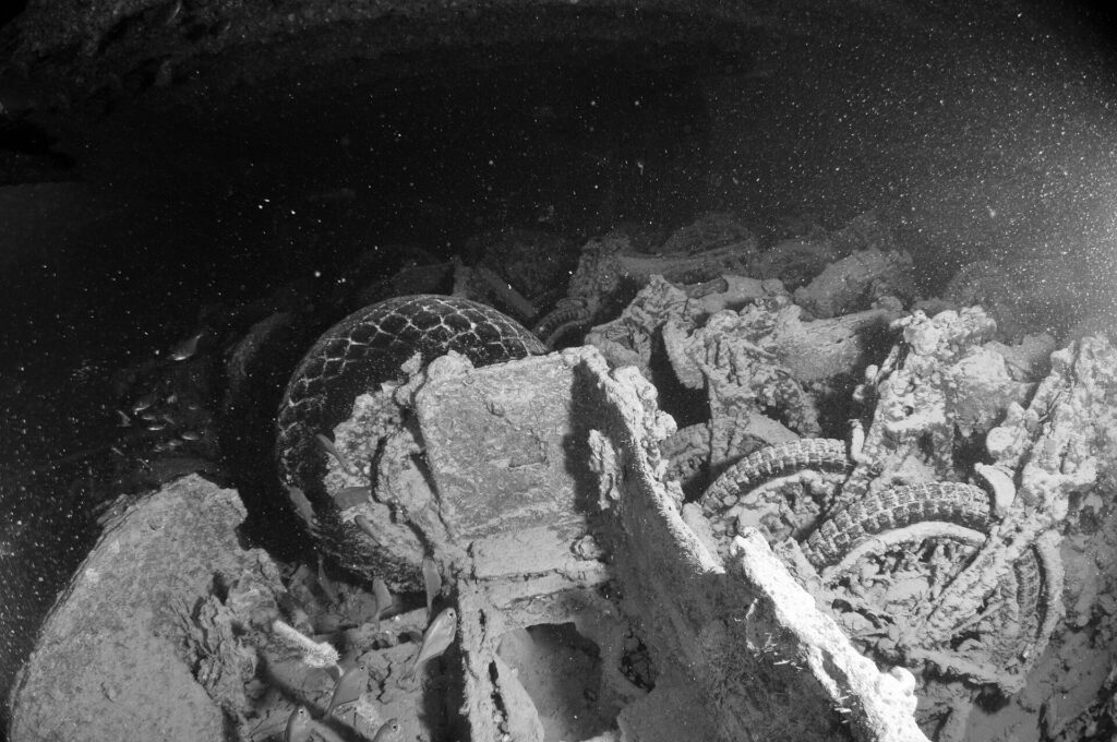 Motos empilhadas no porão do Thistlegorm, foto em preto e branco, com pneus e rodas ainda visíveis