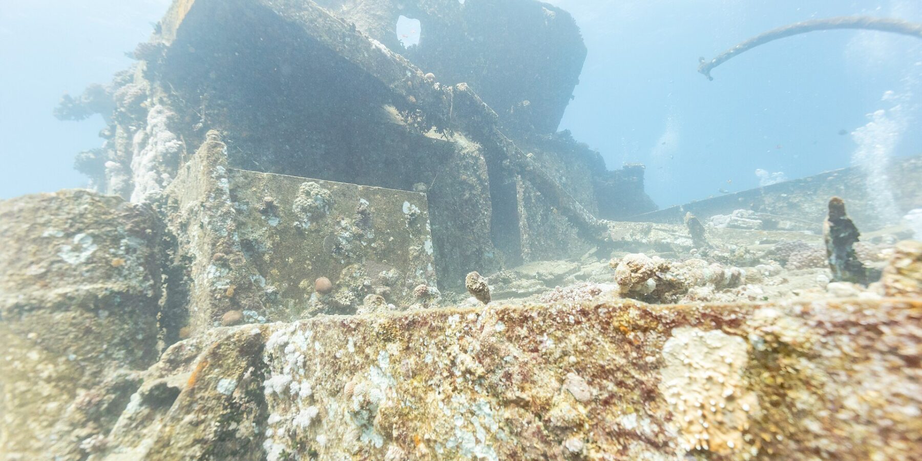 As superestruturas da parte da frente do Thistlegorm cobertas de corais duros, vistas do convés